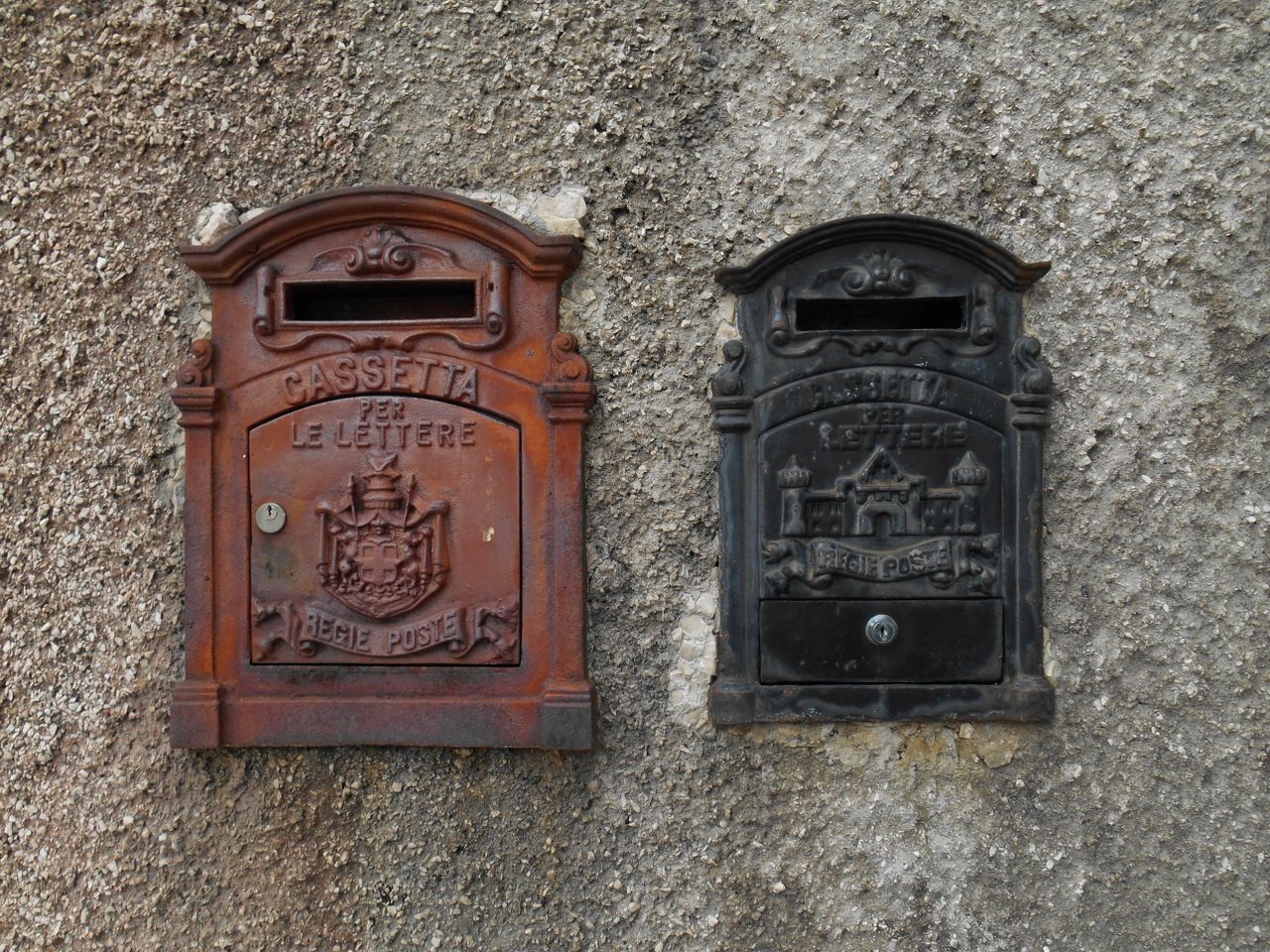 services-01 Two vintage Italian letterboxes mounted on a textured concrete wall.